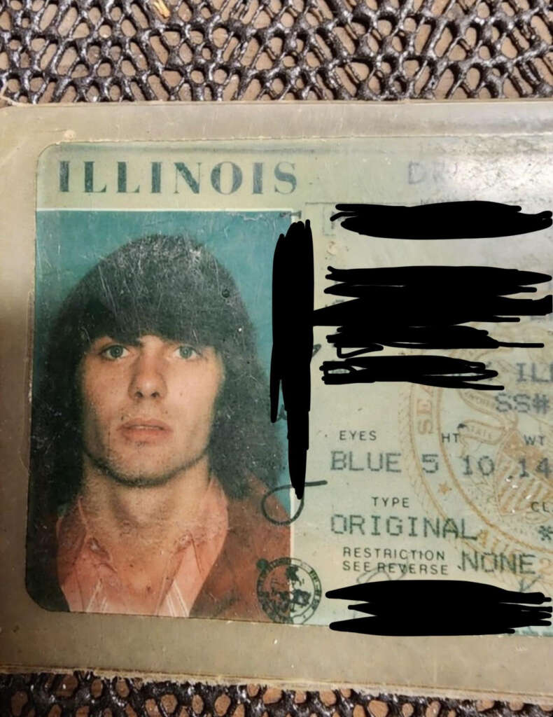 An Illinois driver's license with a photograph of a person with long hair. The text sections including the name, address, and other personal details are blacked out. The details visible include eye color "BLUE," height 5'10", and no restrictions.