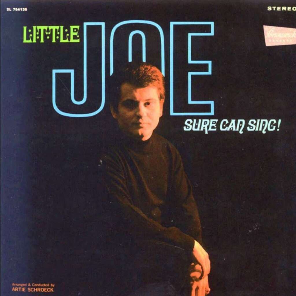 Album cover titled "Little Joe Sure Can Sing!" featuring a man in a black turtleneck photographed in dim lighting against a black background. The text is in bold, blue and white letters. Arranger and conductor credit appears at the bottom left.