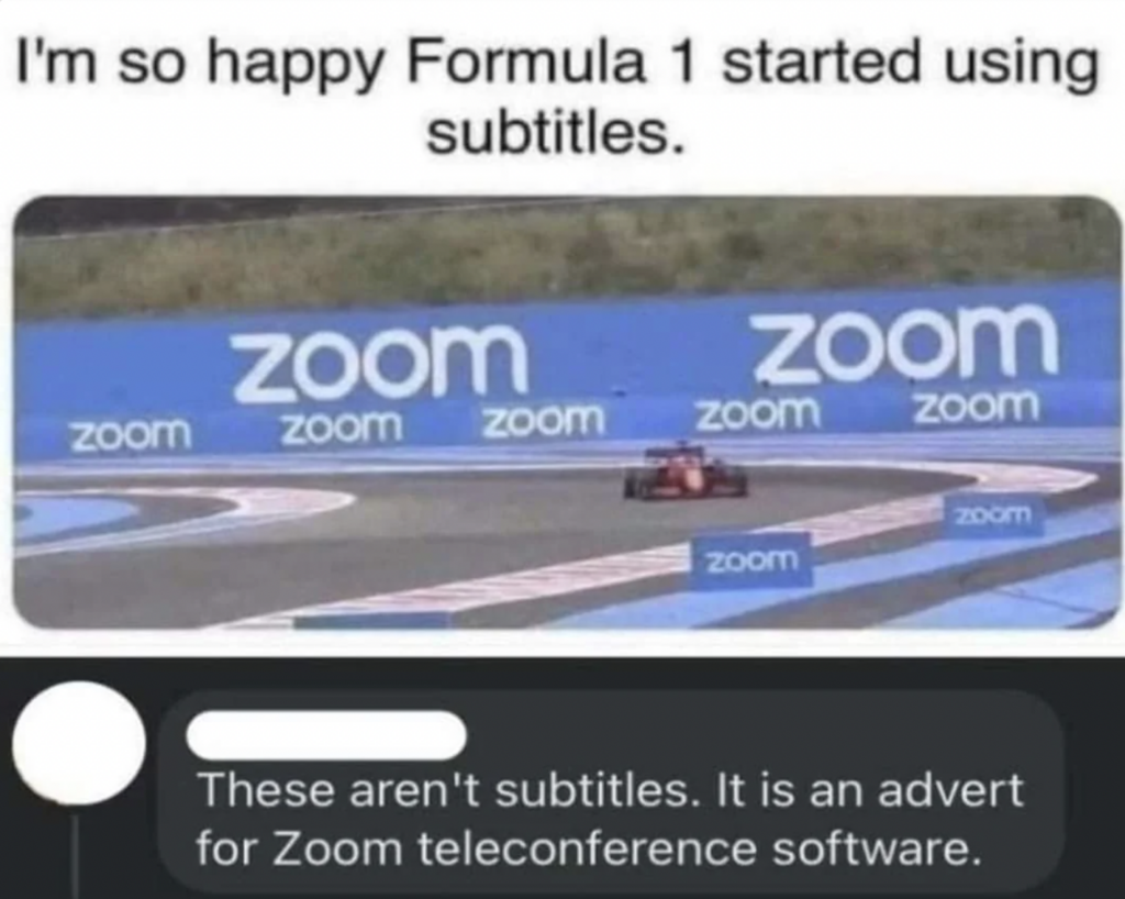 A meme image showing a Formula 1 car on a race track with multiple "Zoom" logos around the track. The top text reads, "I'm so happy Formula 1 started using subtitles." The bottom caption humorously responds, "These aren't subtitles. It is an advert for Zoom teleconference software.