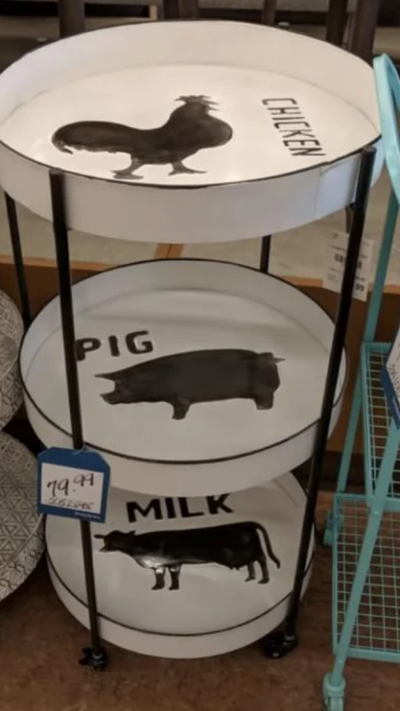 A three-tiered metal tray stand with different animal silhouettes on each tier. The top tier features a chicken, the middle tier has a pig, and the bottom tier shows a cow with the word "MILK" next to it. A price tag reading "$9.99" is attached to the middle tier.