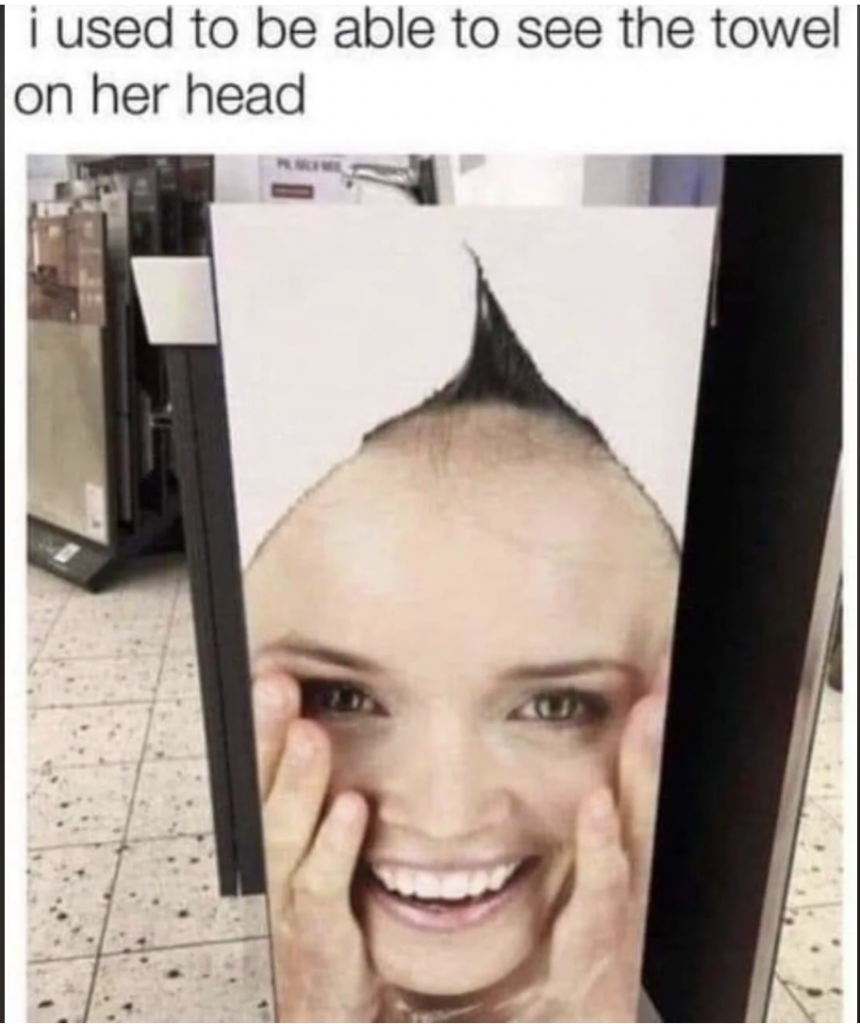 A humorous poster in a store shows a woman's face with a triangular section above her forehead that looks like a pointed hairstyle. A caption above the poster reads, "I used to be able to see the towel on her head.