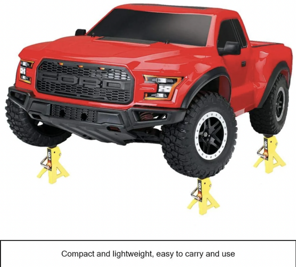 A red remote-controlled toy truck with a detailed front grille and large tires is supported on yellow jack stands. The truck has black windows, and the image caption reads, "Compact and lightweight, easy to carry and use.