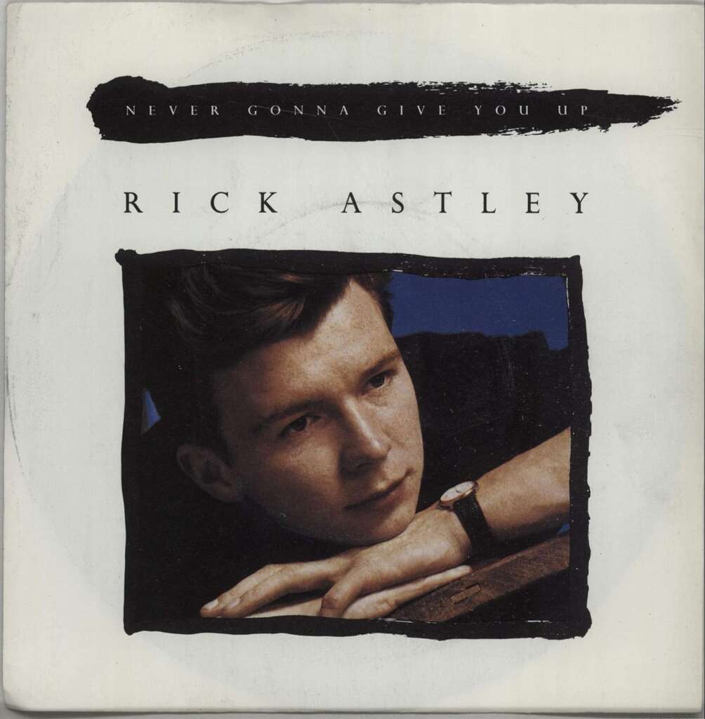 Cover of Rick Astley's single "Never Gonna Give You Up." The image features Rick Astley resting his head on his hands, staring off to the side. Above the photo, text reads “NEVER GONNA GIVE YOU UP”, and below, his name “RICK ASTLEY” is printed.