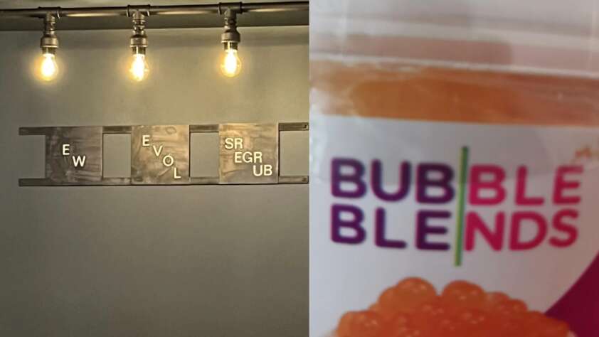A wall art piece with Scrabble-style tiles spells out nonsensical words. Next to it, a close-up of a packaging label for "Bubble Blends" with orange bubble tea pearls visible inside. There are three light bulbs hanging from above on a dark metal fixture.