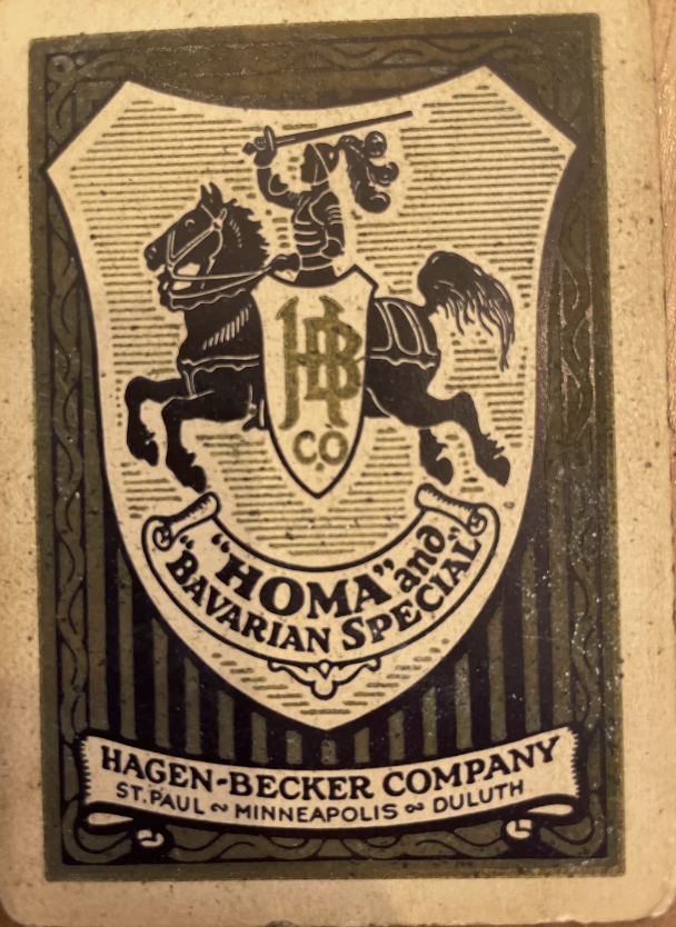 A vintage beer label features a crest with a knight on a horse holding a shield bearing "HB Co." The text reads “Homa and Bavarian Special.” The bottom text reads “Hagen-Becker Company, St. Paul, Minneapolis, Duluth.” The label is bordered by an ornate design.