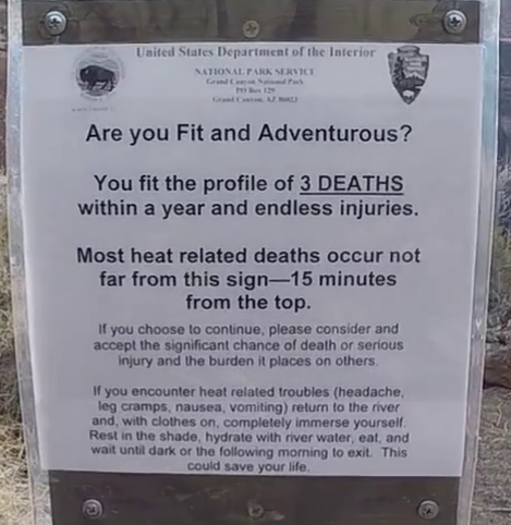 A sign from the United States Department of the Interior, National Park Service, warns about heat-related deaths in the area. It states that most deaths occur within 15 minutes from the sign and advises visitors to return if experiencing heat-related troubles.