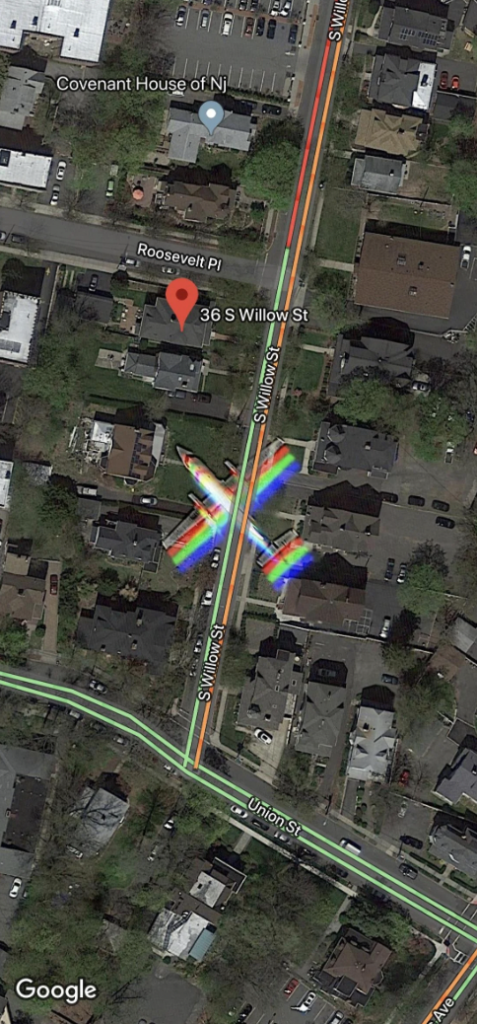 A satellite view of a neighborhood showing streets, houses, and a marked location at 36 S Willow St. There are rainbow-colored light reflections on the road, along with nearby streets labeled as S Union St and Roosevelt Pl. A label for Covenant House of NJ is visible.