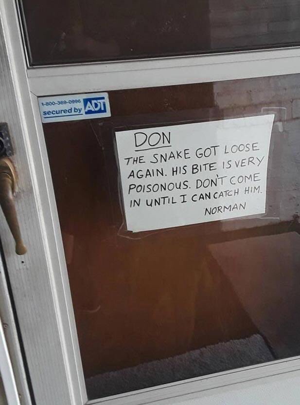 A handwritten note taped to a glass door reads, "DON, THE SNAKE GOT LOOSE AGAIN. HIS BITE IS VERY POISONOUS. DON'T COME IN UNTIL I CAN CATCH HIM. NORMAN." A security sticker from ADT is visible on the door frame.