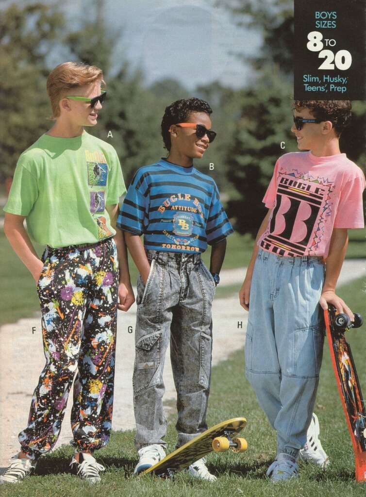 Three boys are standing outside wearing 90s fashion. Boy A wears a green shirt and patterned pants, Boy B wears a striped shirt and denim jeans, and Boy C wears a pink shirt and baggy jeans. They are talking and holding skateboards, with a text "Boys Sizes 8 to 20" visible.