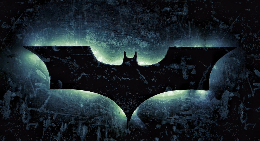 A black silhouette of a stylized bat symbol with outstretched wings is centered against a textured, grungy background with a glowing green aura surrounding the bat. The overall dark and moody tones suggest a mysterious and ominous atmosphere.