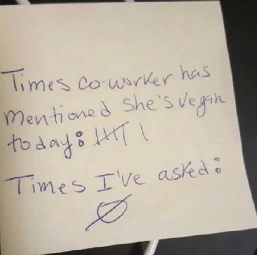 A sticky note with handwritten text reads: "Times co-worker has mentioned she's vegan today: |||| 1 Times I've asked: ⌀" There are four vertical tally marks and another tally mark crossed with a horizontal line next to the first statement.