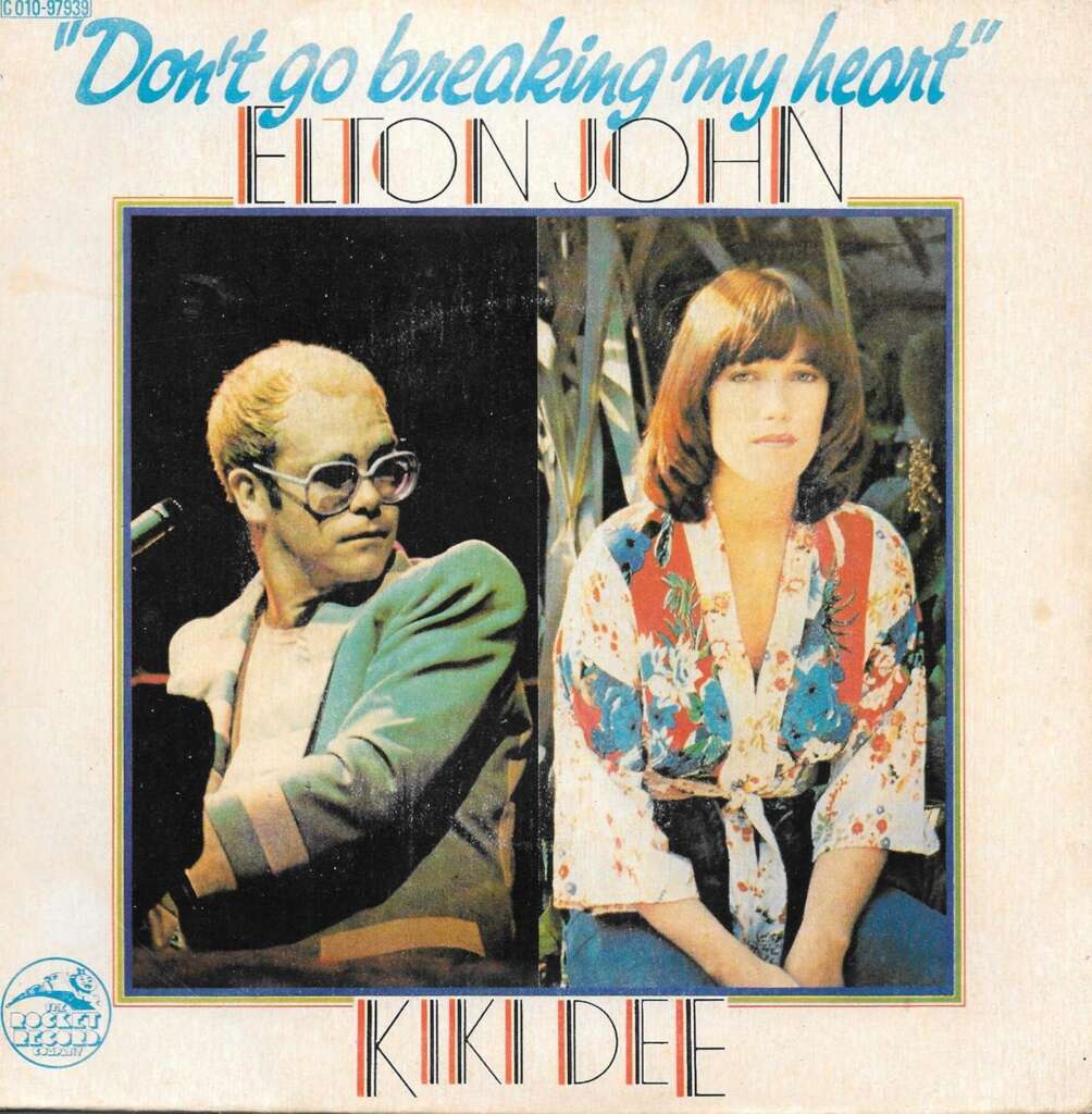 An album cover featuring Elton John and Kiki Dee for the song "Don't Go Breaking My Heart." On the left, Elton John is wearing glasses and holding a microphone. On the right, Kiki Dee is dressed in a floral blouse and looking towards the camera.