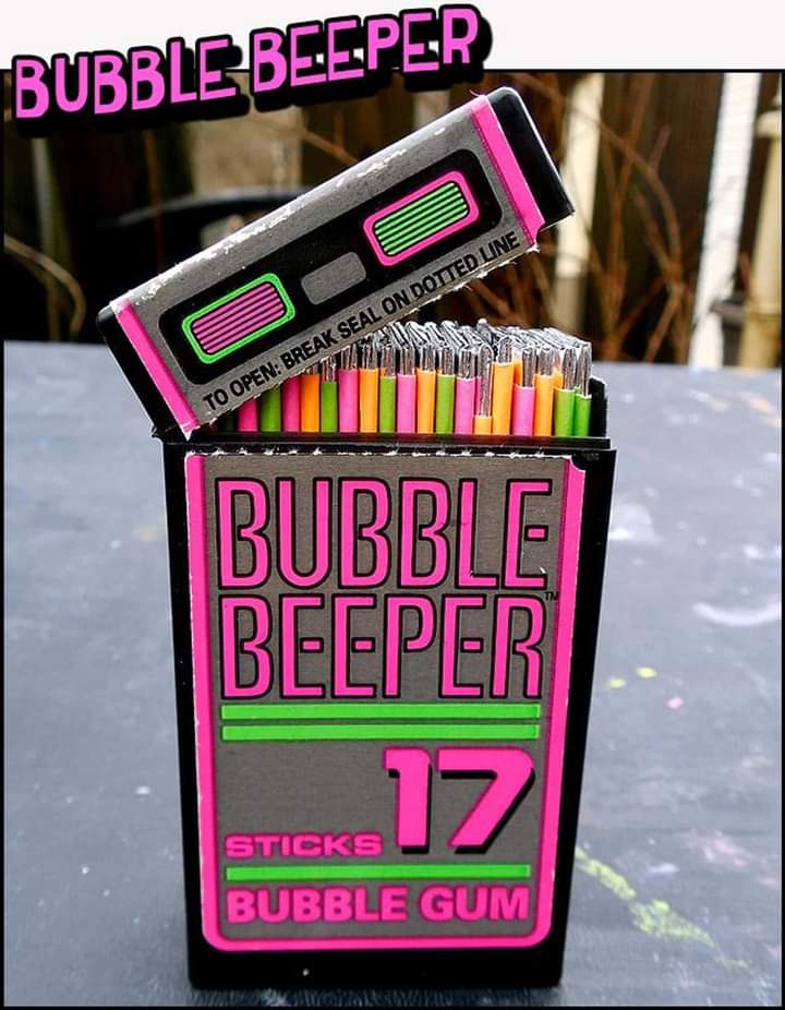 A colorful retro-style pack of "Bubble Beeper" bubble gum sticks with a vibrant design. The pack resembles a pager, featuring bright neon colors of pink, green, and black. The text reads "Bubble Beeper" and "17 Sticks Bubble Gum" on the front.