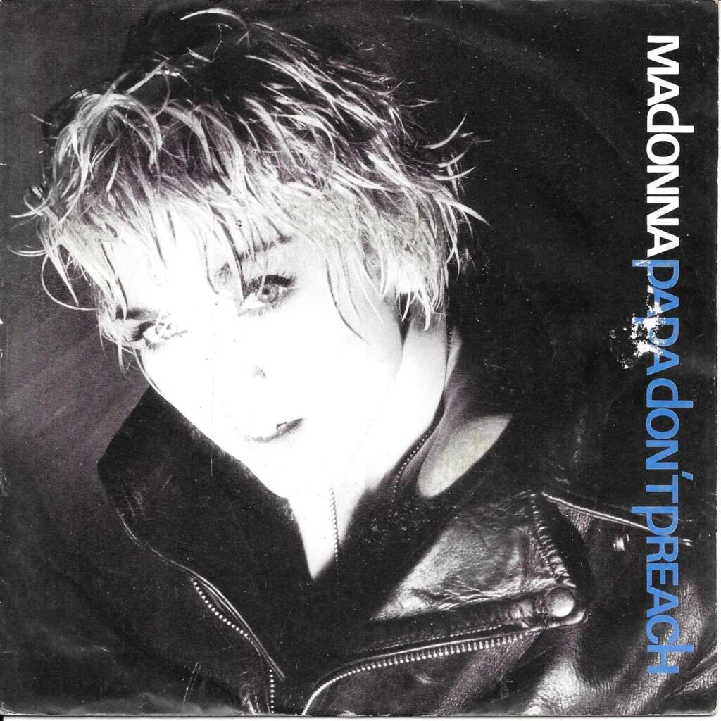 Black and white cover of Madonna's "Papa Don't Preach" single shows her with short, tousled hair, wearing a leather jacket. The title is written along the right edge in white and blue text. The overall tone of the cover reflects a rebellious and edgy theme.