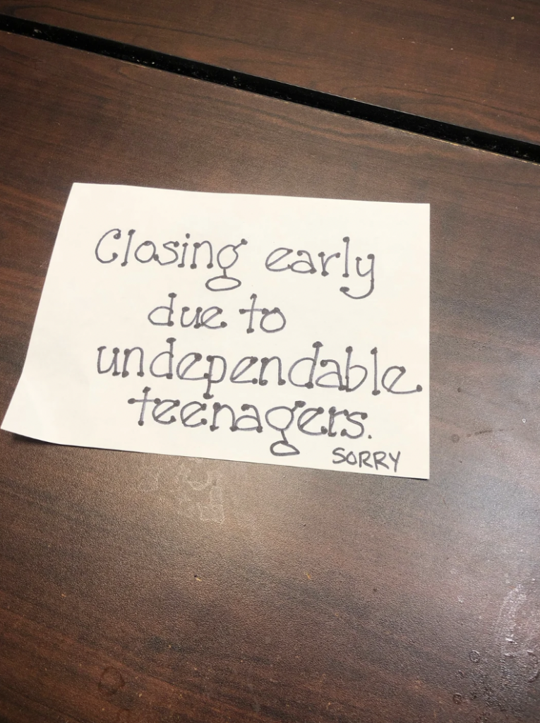 A hand-written sign on a wooden surface reads, "Closing early due to undependable teenagers. SORRY.