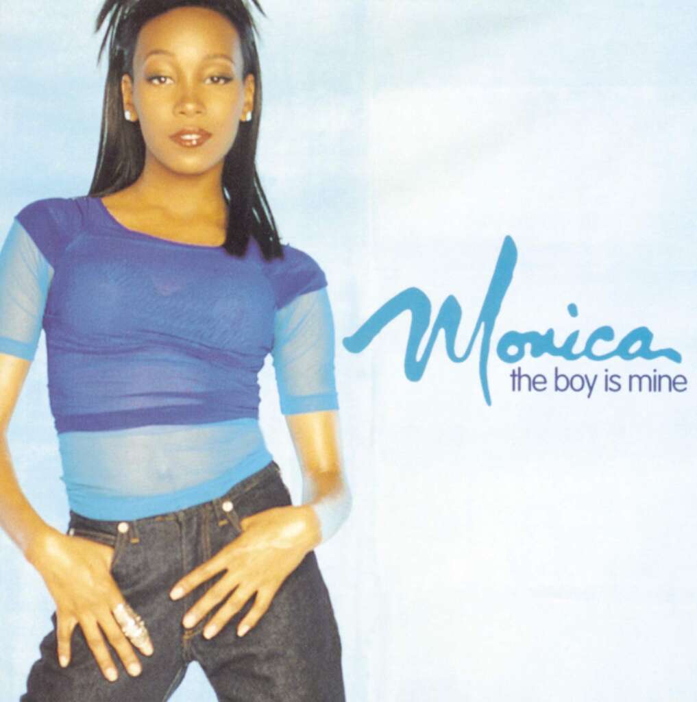 A person is standing against a light blue background. They are wearing a blue sheer top over a blue tank top and dark jeans. The text "Monica" and "the boy is mine" is written on the right side of the image.