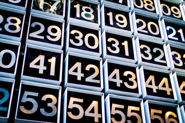 A close-up image of large black boxes numbered sequentially from 18 to 57. Each box has bold white numbers on the front, arranged in a grid pattern. The numbers stand out prominently, and the boxes appear to be part of a larger display or installation.