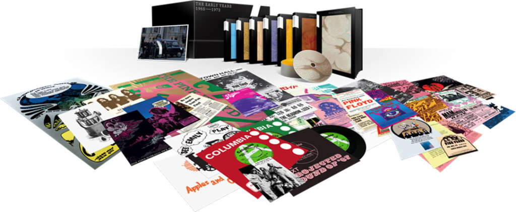 Classic rock box sets - A collection of various music-related items is displayed, including vinyl records, album covers, posters, and booklets. The centerpiece includes a boxed set titled "The Early Years 1965-1972" and a round white object with a geometric pattern.