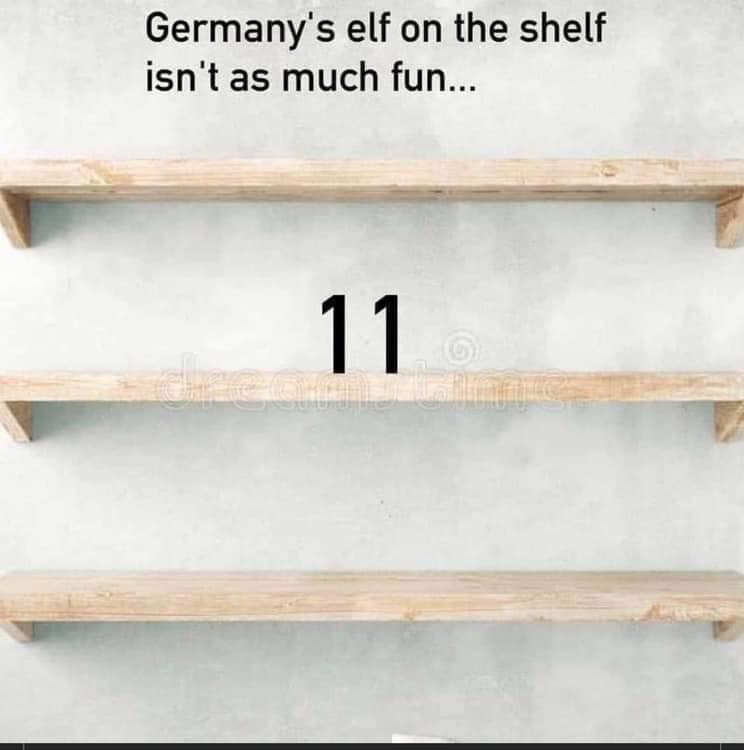 Three wooden shelves are mounted on a wall in a minimalistic style. Between the middle shelf and the bottom shelf, the number '11' is displayed prominently. Above the top shelf, text reads, "Germany's elf on the shelf isn't as much fun...