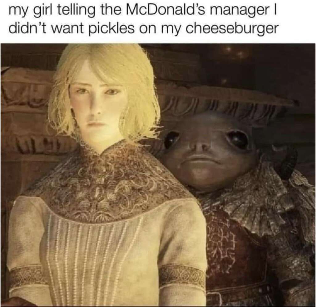 A medieval-styled image with a serious-looking woman in detailed attire standing in the foreground. Behind her, a peculiar frog-like creature with armor looks on. The text above reads, "my girl telling the McDonald’s manager I didn't want pickles on my cheeseburger." Elden Ring memes energy.
