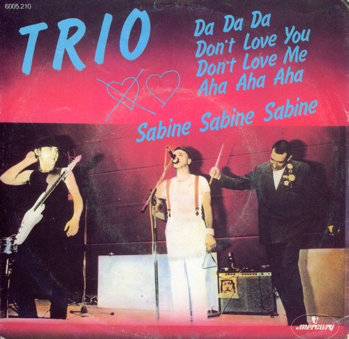 Album cover featuring three band members performing on stage with instruments. The background is red and black with blue text listing song titles: "Da Da Da," "Don't Love You," "Don't Love Me," and "Aha Aha Aha." The name "Sabine Sabine Sabine" is highlighted.