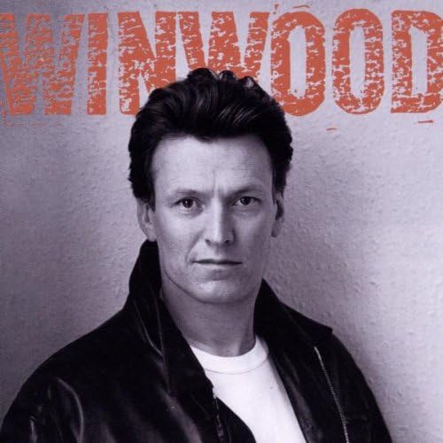 Monochrome photo of a man with a serious expression, wearing a white t-shirt and a dark leather jacket. "WINWOOD" is written in bold, textured orange letters at the top of the image. The background is plain and light-colored.