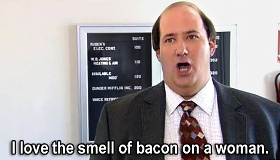 A man in a suit stands in front of an office directory board, saying, "I love the smell of bacon on a woman.