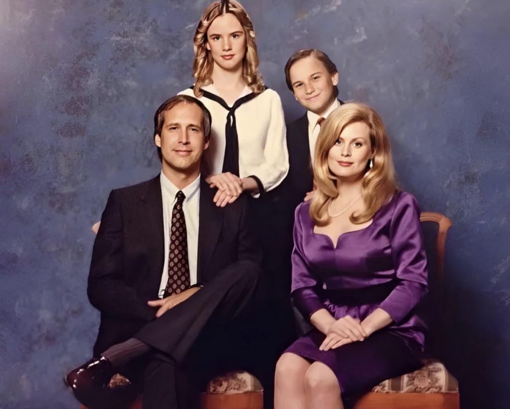 A family portrait features two adults and two children posed against a blue background. The man, seated, wears a suit, and the woman, also seated, wears a purple dress. The girl in the middle and a younger boy on the right, both stand smiling behind them.