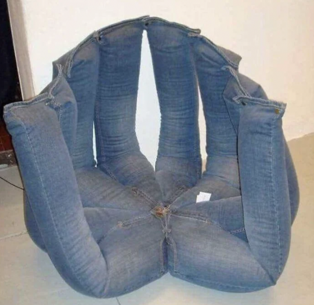 This is a photo of an unusual chair made from repurposed denim jeans. The jeans are arranged in a circular, upright fashion to form the backrest, while the seat is fashioned from the lower part of the jeans. The chair has a quirky, creative appearance.