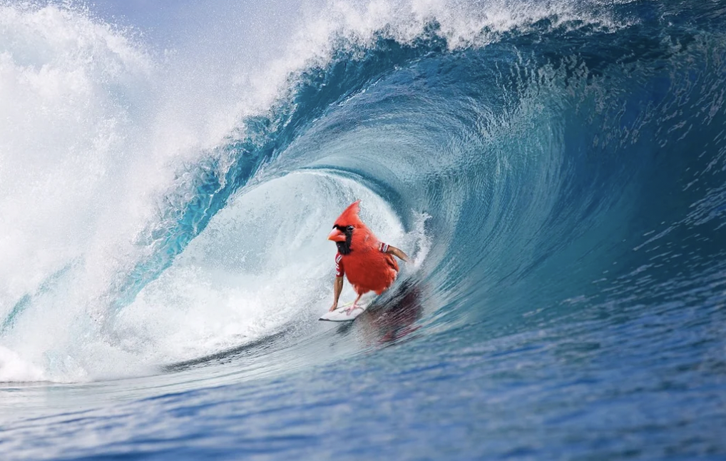 A vibrant red cardinal bird expertly rides a surfboard on a powerful, curling ocean wave, surrounded by splashing water and the blue sea.