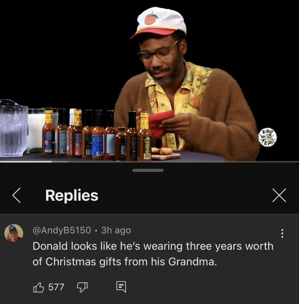 A man in a colorful hat and sweater sits at a table with multiple bottles of hot sauce and a pitcher of water. Beneath the image, a comment reads, "Donald looks like he's wearing three years worth of Christmas gifts from his Grandma," with 577 likes.