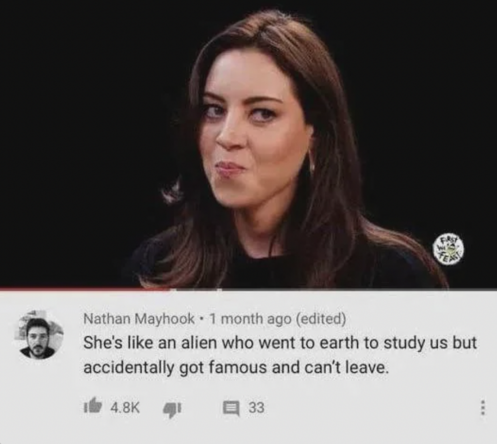 A woman with long brown hair and a mischievous expression on her face is looking slightly to the side. Below the image is a comment from Nathan Mayhook that reads, "She's like an alien who went to earth to study us but accidentally got famous and can't leave." The post has 4.8K likes and 33 replies.