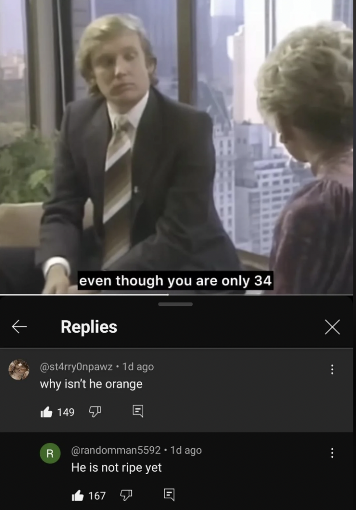 A man in a suit and tie is having a conversation with a woman in a business setting with large windows in the background. Subtitles read, "even though you are only 34." Below are comments, with one asking why the man isn’t orange and another responding he isn’t ripe yet.