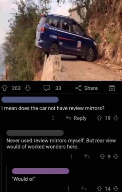 A car teeters dangerously off the edge of a narrow, steep road with a drop-off to the side. Below the image, a social media post and comments discuss whether the car used "review mirrors," with one commenter humorously correcting "review" to "rear view.