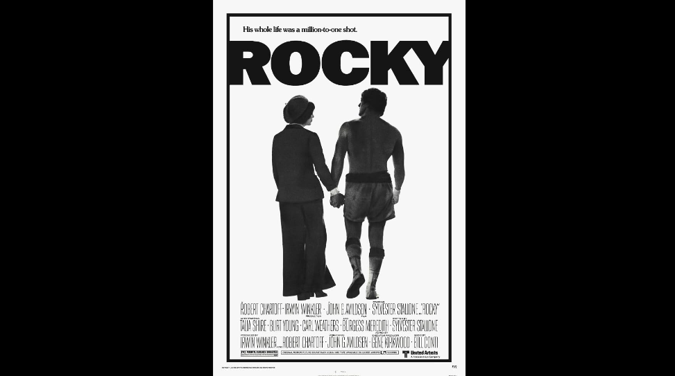 A black and white movie poster for "Rocky." It features the title "ROCKY" in large bold letters at the top. Below, two individuals, one in athletic gear and the other in a dress, walk away while holding hands. The phrase "His whole life was a million-to-one shot" appears above.