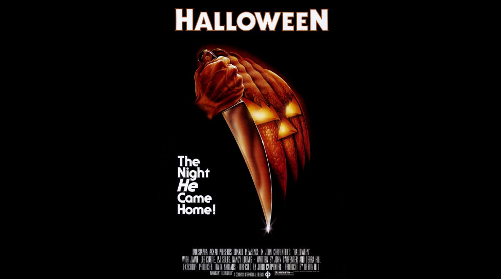 A dark poster for the movie "Halloween" featuring a hand holding a large knife with a pumpkin in the background. The pumpkin's segments resemble a grinning face. Text reads, "HALLOWEEN" at the top and "The Night He Came Home!" to the left of the knife.