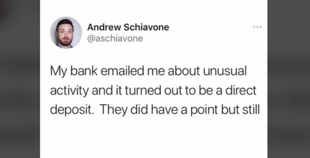 A tweet from Andrew Schiavone (@aschiavone) reads, "My bank emailed me about unusual activity and it turned out to be a direct deposit. They did have a point but still." A profile picture of a bearded man is also visible.