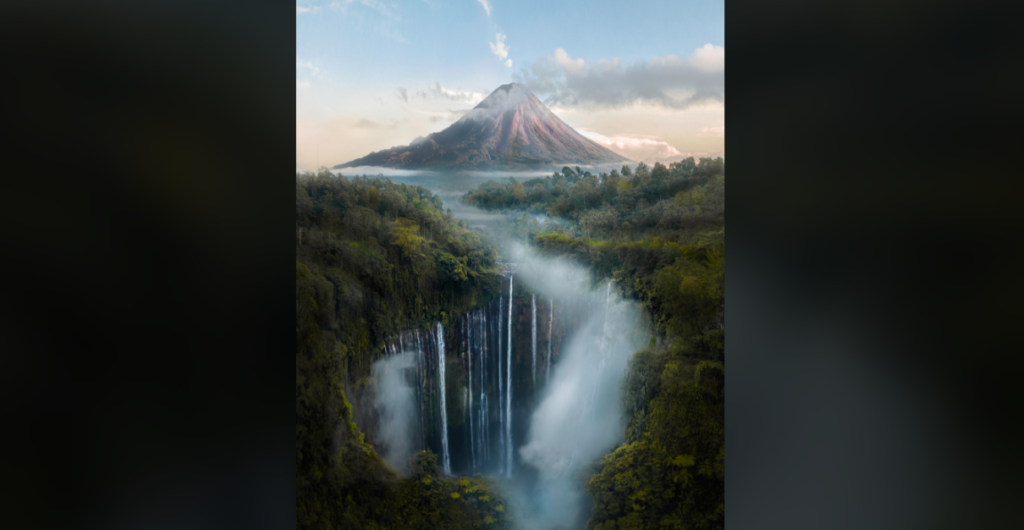 A breathtaking landscape featuring a tall, majestic waterfall cascading into a lush, forested canyon. In the background, a towering volcano with a cloud-covered peak stands against a blue sky with wisps of clouds, creating a serene and dramatic scene.