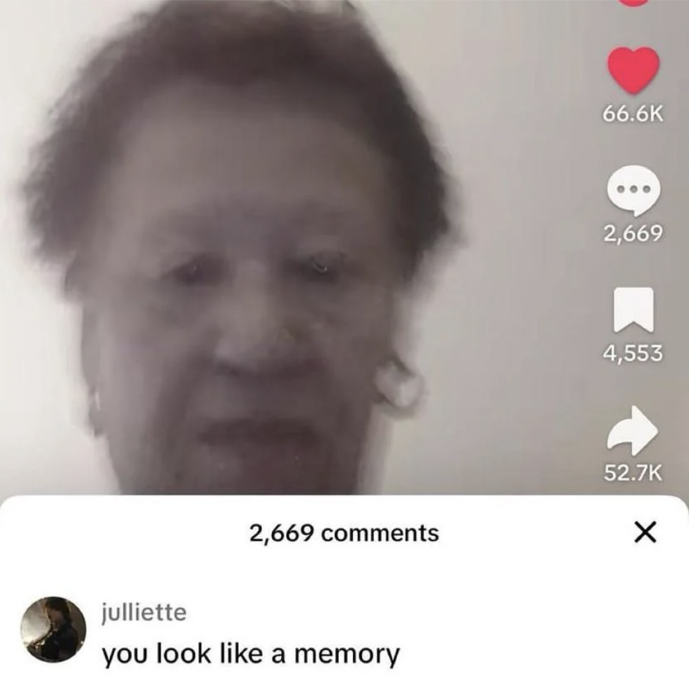 A screenshot from a social media platform showing an elderly person with short hair and earrings. The image is slightly blurred. A comment below reads, "you look like a memory." The post has received 66.6K likes, 2,669 comments, 4,553 shares, and 52.7K reactions.