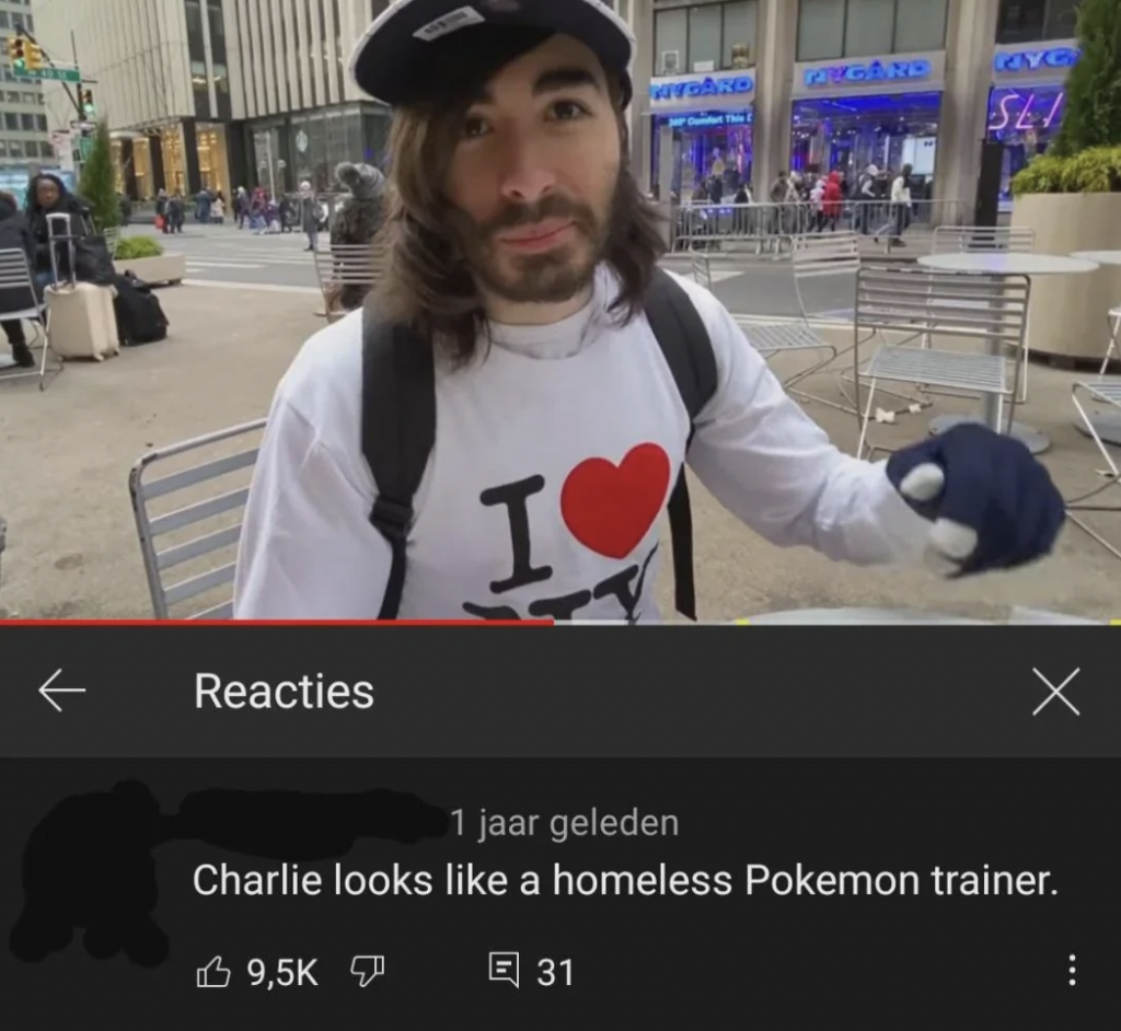 A person with long hair and a beard wearing a white "I Love NY" shirt and a cap is standing outdoors in a city environment. Below the image is a YouTube comment saying, "Charlie looks like a homeless Pokemon trainer," with a high number of likes and replies.