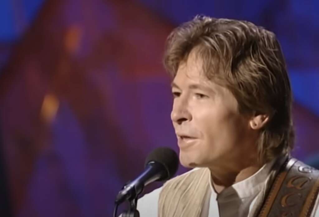 John Denver Quotes - John Denver on stage singing into a microphone