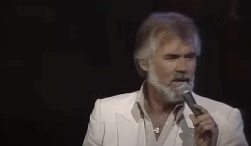 Kenny Rogers Quotes - Photo of Kenny Rogers on Stage singing into a microphone