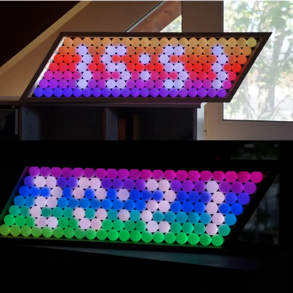 An LED display shows "1989" in red, pink, and purple lights in the top half. The bottom half displays "2021" in vibrant multicolors on a frame tilted at an angle, positioned near a window.