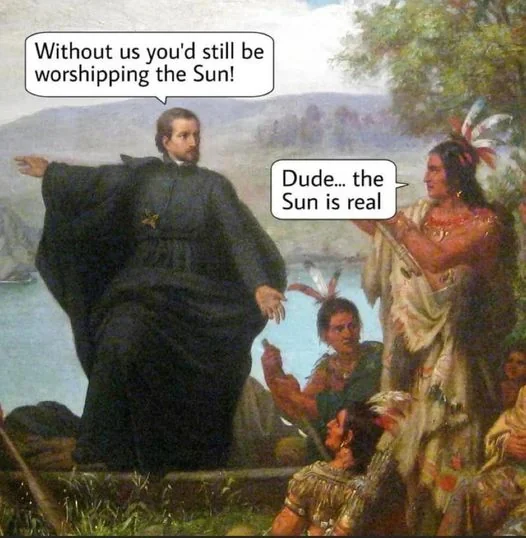 A historical-style painting shows a priest saying, "Without us you'd still be worshipping the Sun!" to a Native American who replies, "Dude... the Sun is real." Other Native Americans are seated around them.