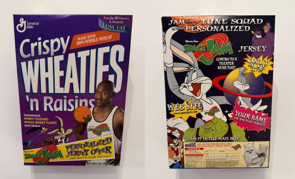 Front and back view of a Crispy Wheaties 'n Raisins cereal box featuring Space Jam graphics. The front shows a basketball player, and the back highlights a promotion for a personalized Tune Squad jersey. Bugs Bunny and other characters are illustrated.