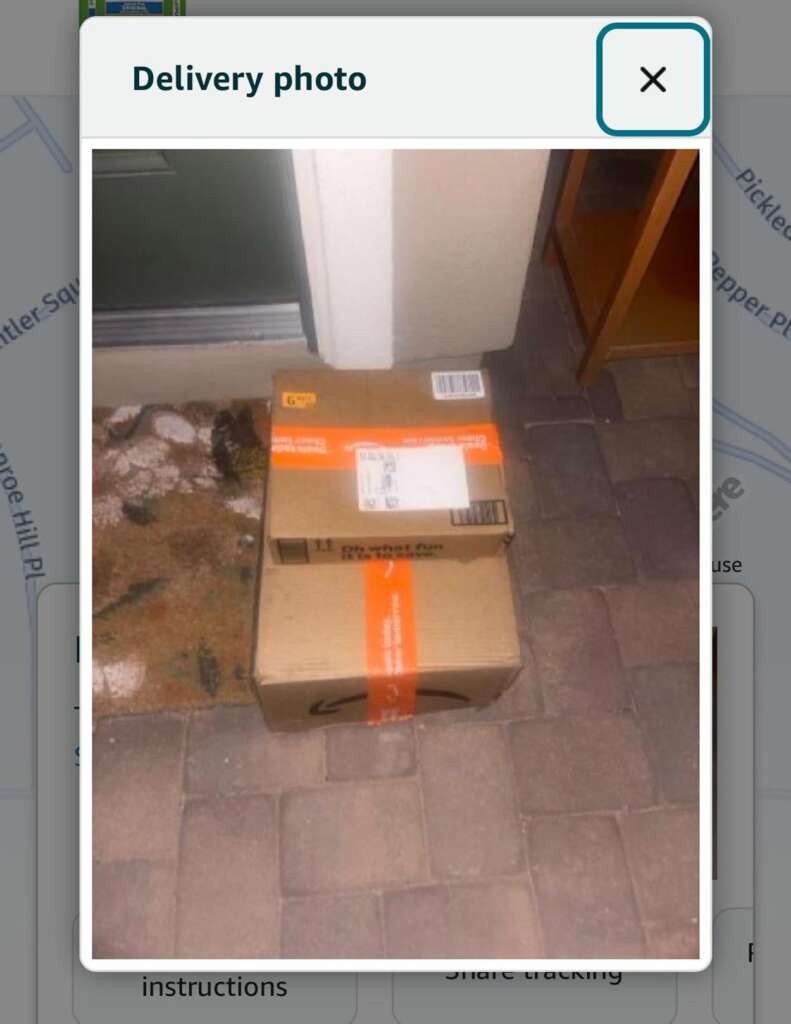 Nightmare neighbors - Two cardboard boxes are placed on a door mat in front of a green door. The top box has shipping labels, and the mat features a leaf pattern. The boxes are situated on a stone-tiled doorstep.