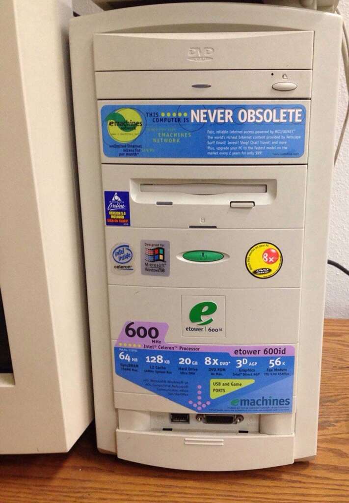 A vintage eMachines computer tower with several colorful stickers showcasing its features, including a 600 MHz Intel Celeron processor, 64 MB RAM, and 8x CD-ROM. The stickers also emphasize upgradability and internet readiness.