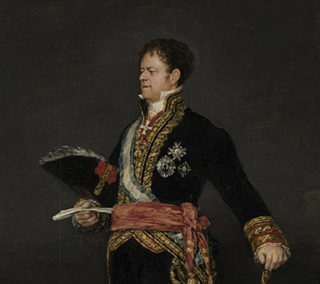 A portrait of a man in ornate military attire, featuring a richly decorated black coat with gold embroidery, a sash, and several medals. He holds a feathered hat in one hand and a paper in the other, standing against a dark background.