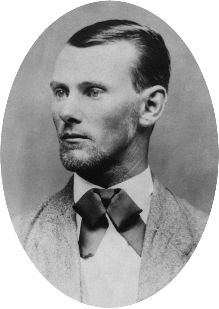 A vintage black and white oval portrait of a man with short hair and a beard, wearing a suit with a bow tie. He is looking slightly to the left. The style suggests a historical era photograph.