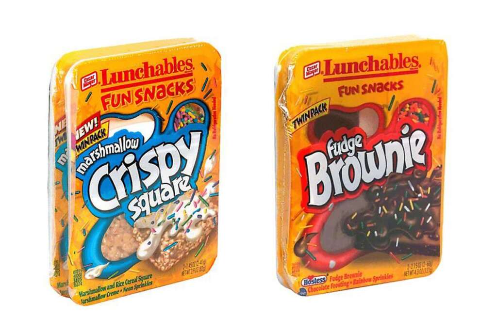 Two packs of Lunchables Fun Snacks. One pack is "Marshmallow Crispy Square" with colorful sprinkles on the package. The other is "Fudge Brownie" with chocolate sprinkles on the package. Both are bright and colorful.